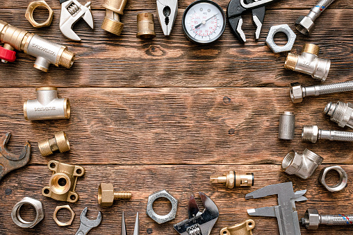 Plumbing flat lay background with copy space. Work tools and pipeline parts on plumber workbench.